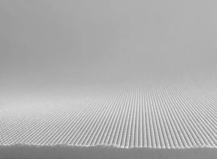 Close-up of 401 fabric in white, displaying a fine ribbed texture with a smooth surface, ideal for technical, performance, or medical textile applications.